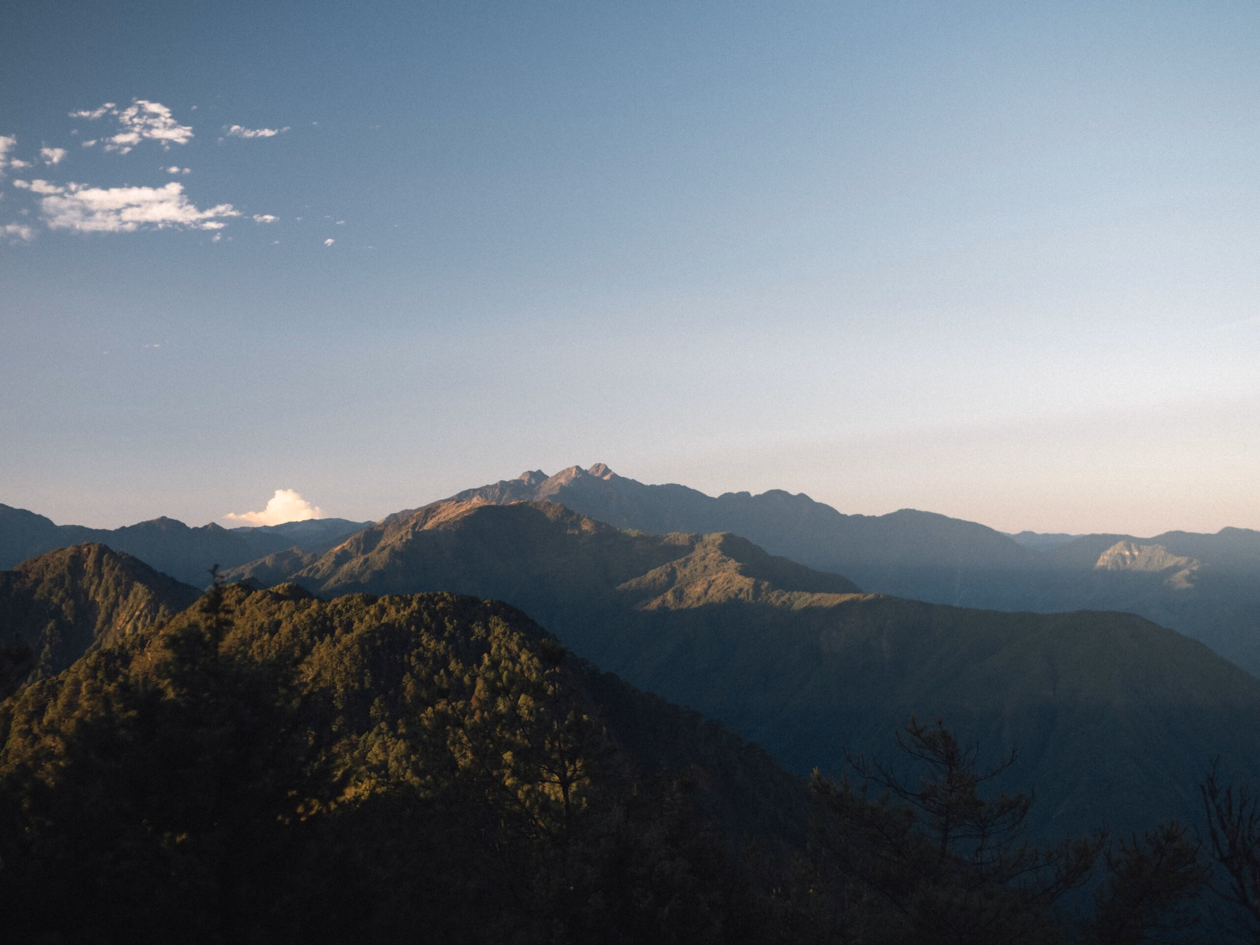 黎明的山稜線，逆光下層層山脊與遠方雲海