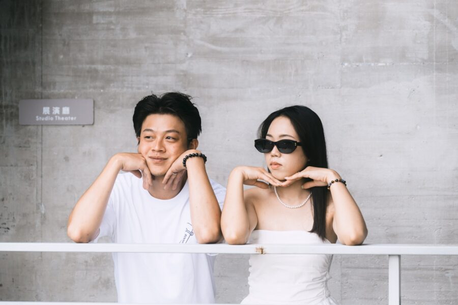 兩人倚著白色欄杆,手托下巴看向鏡頭