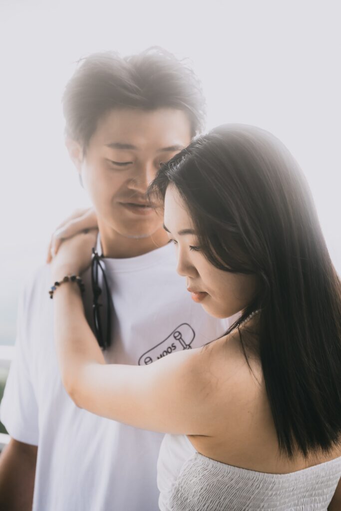 兩人相擁，女生低頭微笑