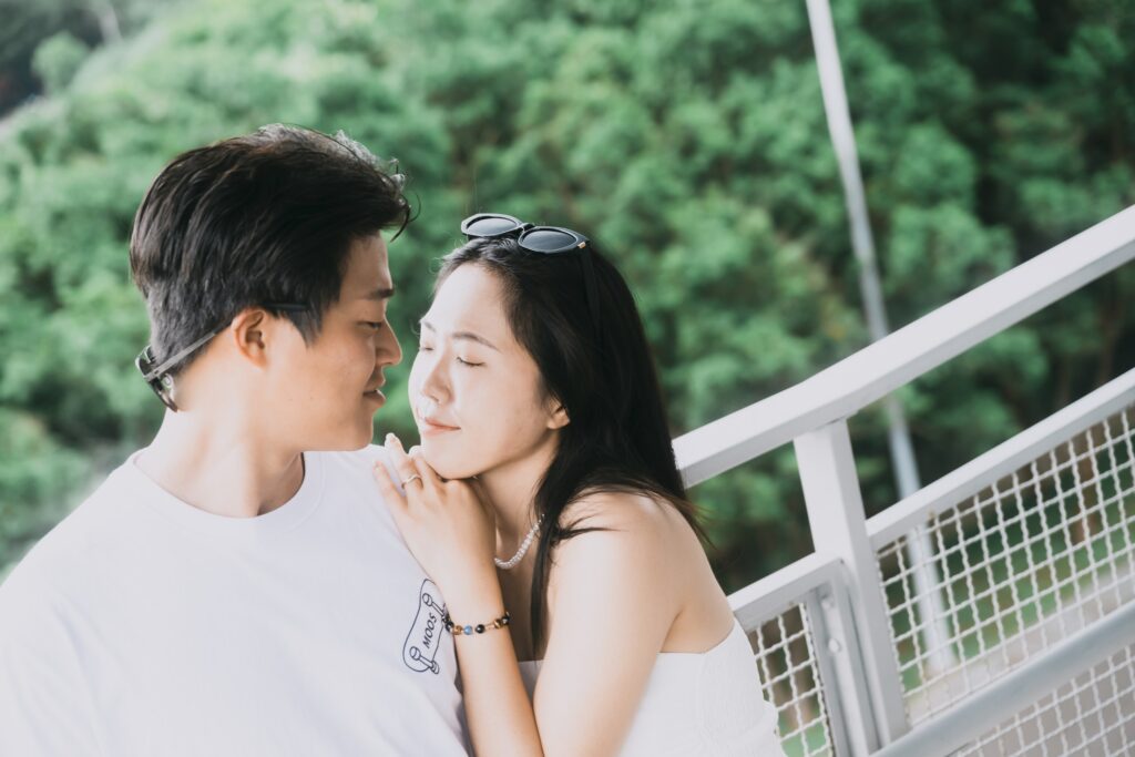 兩人額頭相靠，身後是山坡的樹林