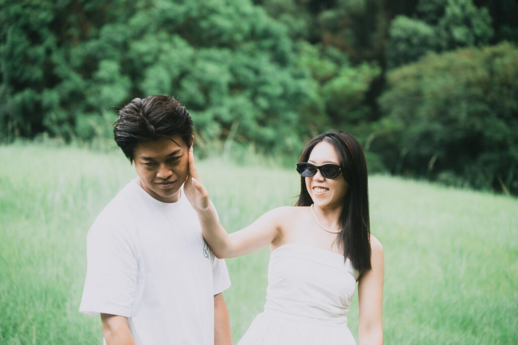 草地上，女生伸手指著男生