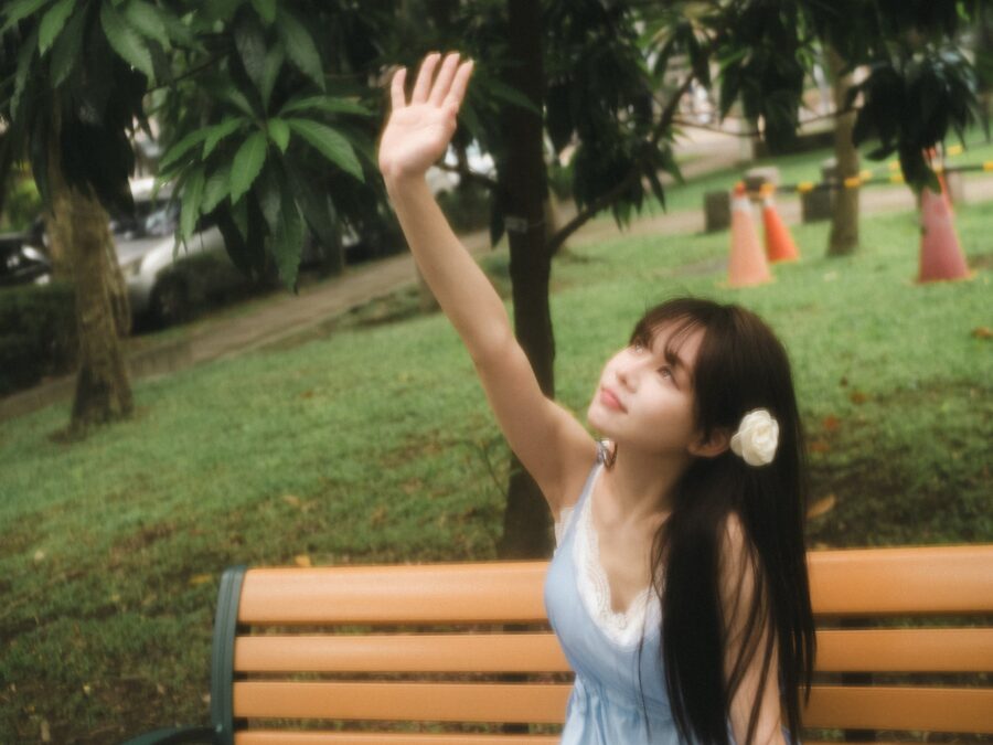 在長椅後舉手的女子