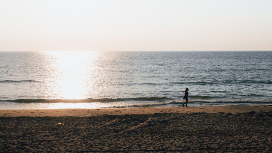 夕陽下的海平面與沙灘上的人
